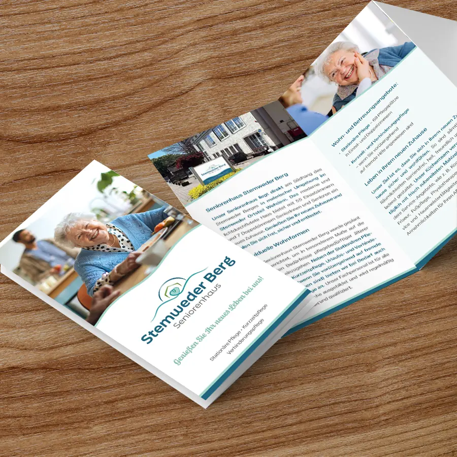 flyer_kreis_stemwede Informationsbroschüre des Seniorenhauses Stemweder Berg liegend auf einem Holztisch